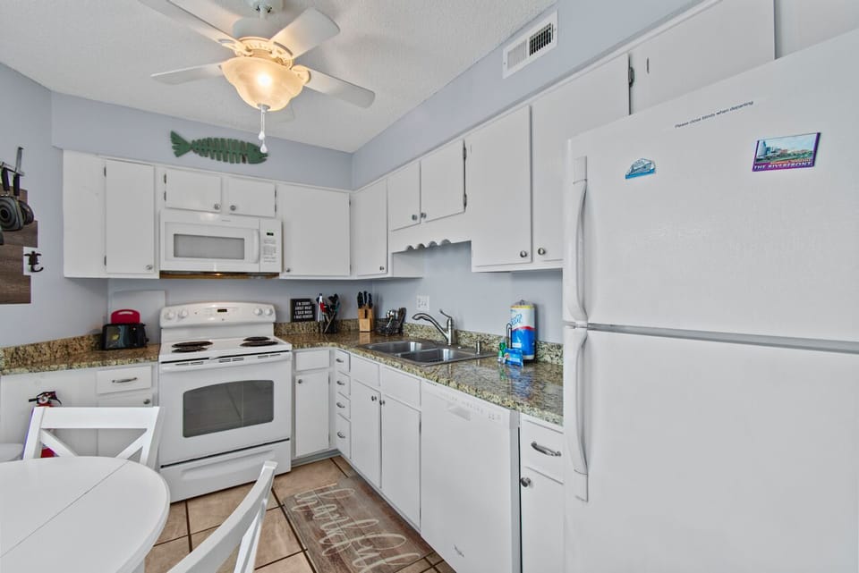 Your fully-equipped kitchen awaits with granite counters, crisp white cabinets, and all appliances needed for home-cooked meals.