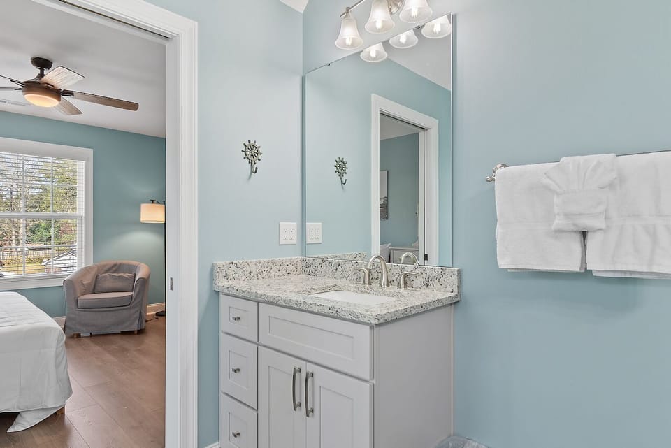 Freshen up in your private spa-like bathroom with elegant granite countertops and modern vanity lighting.