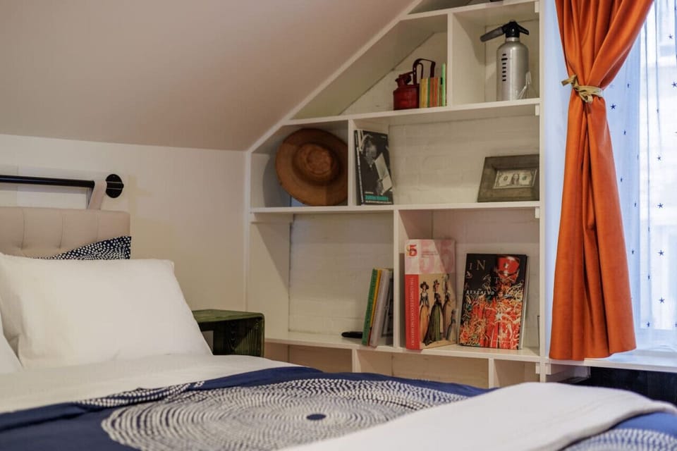 A cozy reading nook and built-in shelving offer both comfort and charm in this attic hideaway.