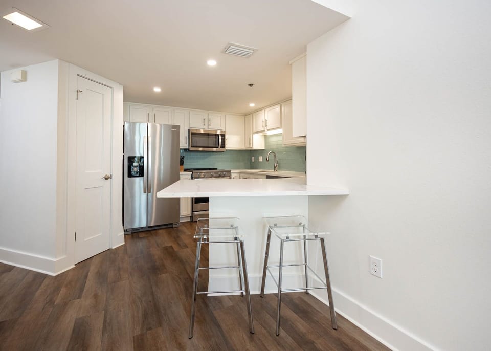 Gather around the sleek kitchen space with stylish seating, perfect for casual meals and conversation