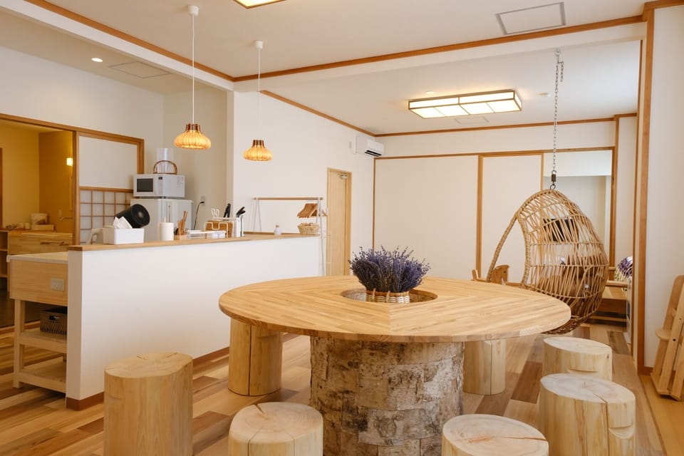 In the spacious living room, there is a round table and log chairs with the original white birch motif of Ventean House.