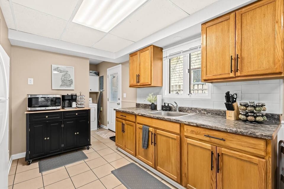 Modern meets classic in this bright kitchen, featuring warm wood cabinetry and sleek appliances—your culinary haven away from home