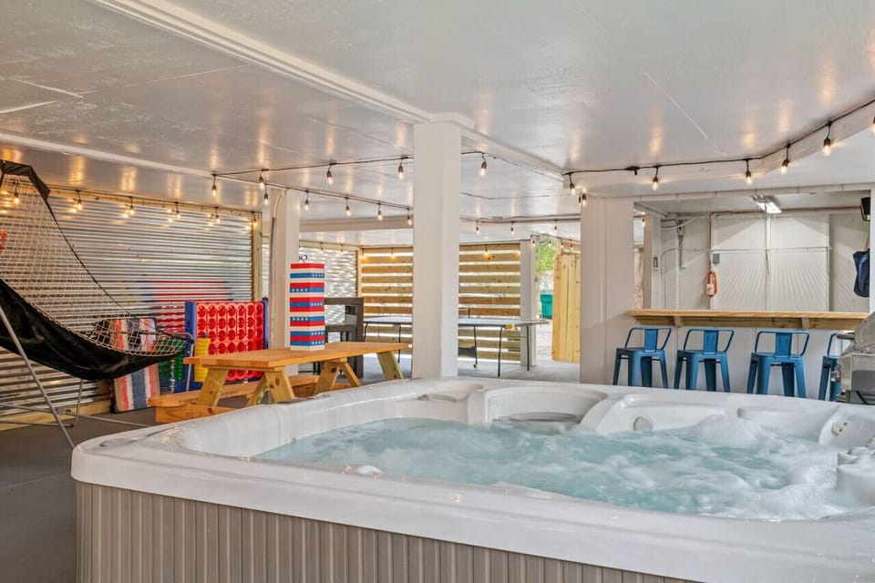 Take in the full view of our patio, showcasing various entertainment options accessible from the hot tub.