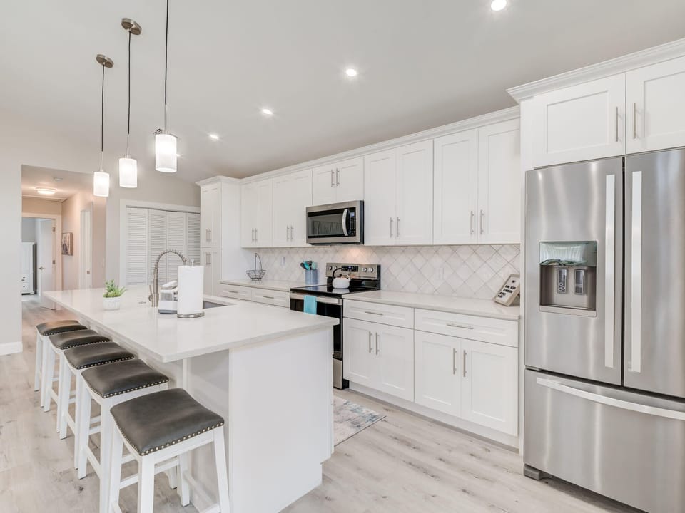 Spacious Kitchen: Modern design with sleek finishes and inviting island seating for dining and gathering.