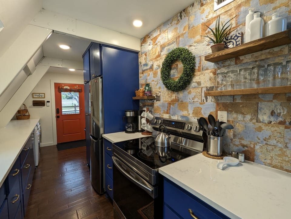 Stainless steel refrigerator and electric 5 burner stove and single oven.