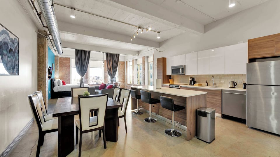 Open Concept Living Area: Bright, modern space with sleek kitchen and city skyline views!