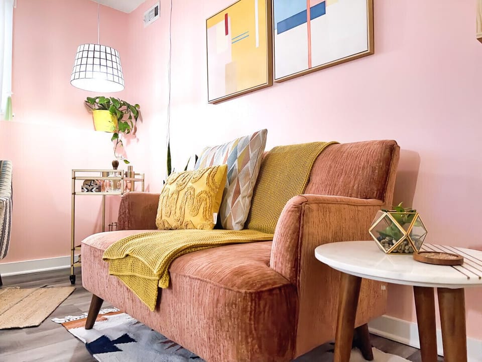 Sidle up to style! Our pink chair, adorned with vibrant yellow accent pillows, beckons you. The backdrop? A chic mini bar, promising evenings of charm and indulgence. Take a seat, soak it in, and let the relaxation unfold. -StayAwhile-