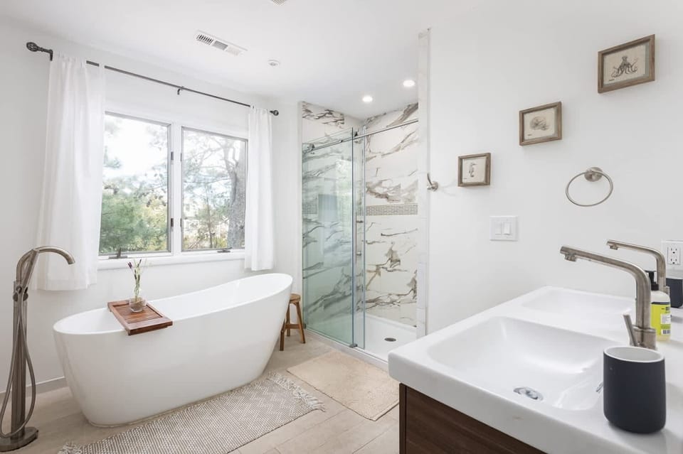 Gorgeous ensuite queen master bath featuring a freestanding soaking tub, double vanity, and a custom marble-tiled walk-in shower