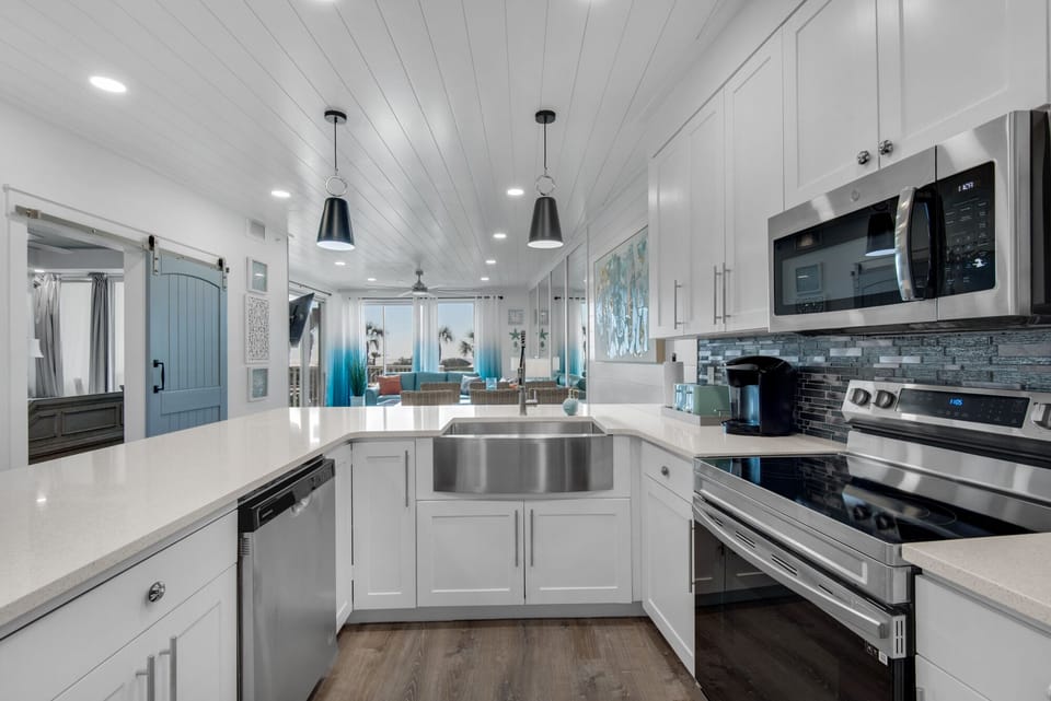 Your chef-worthy kitchen features gleaming granite counters, stainless appliances, and coastal charm with shiplap ceilings and ocean-blue accents.
