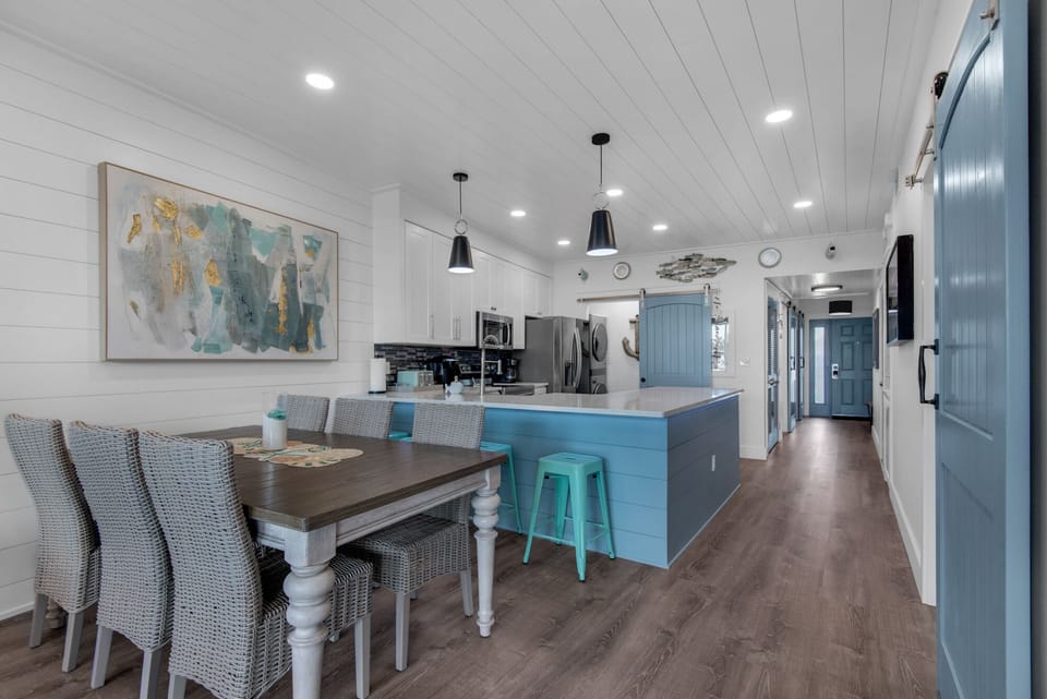 Your spacious kitchen flows seamlessly into the dining area, featuring coastal blues and modern appliances perfect for memorable meals together.
