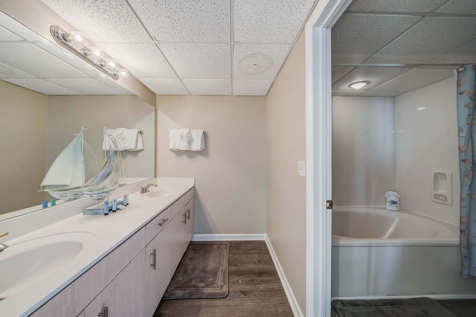 The ensuite bathroom features double sinks, an oversized soaking tub/shower, and a separate water closet.