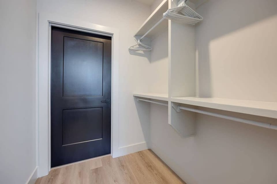 Primary bedroom with King bed, smart TV, large walk-in closet, and ensuite bathroom with walk-in shower.