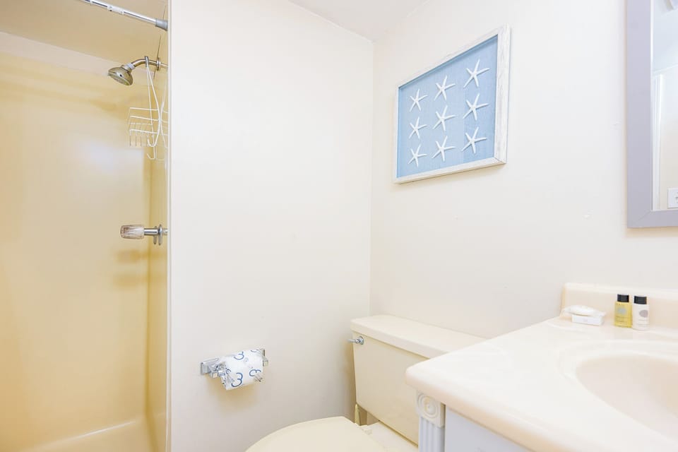The master bath offers a peaceful spot to refresh with a shower and soothing coastal decor on the wall