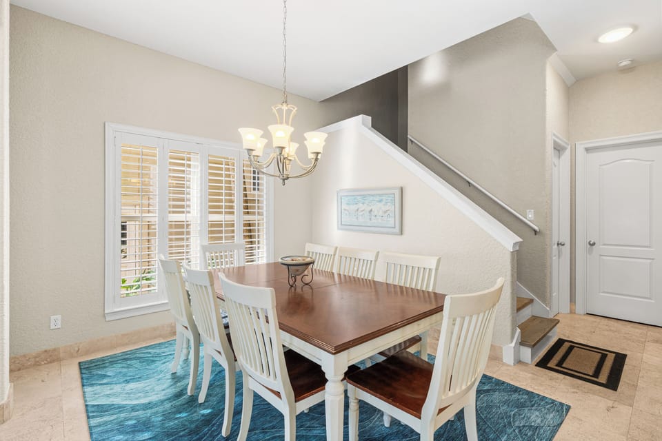 Gather around this elegant dining table where memorable meals await. The soft chandelier light creates perfect ambiance for your conversations.