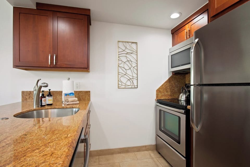With smooth stone counters and cherry-toned charm, this cozy kitchen stirs up comfort and a hint of wanderlust