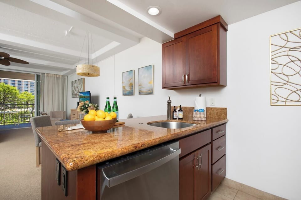 Warm wood, golden granite, and stainless sparkle, this chic kitchen feels like a recipe kissed by island sunshine