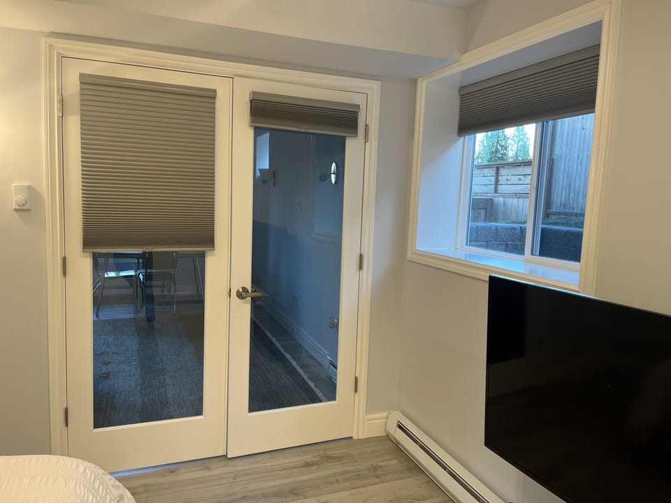 French doors in between the living room and the primary bedroom.  Black