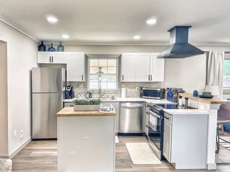 Open-concept kitchen with stainless appliances, island prep space, and full cookware.