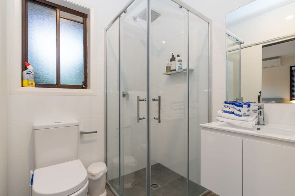 Modern bathroom equipped with a refreshing shower and a clean toilet, offering everything you need for a comfortable stay.