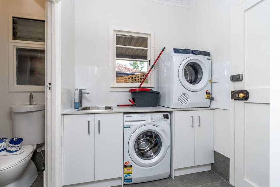 Practical laundry area with essential amenities, including a washer and dryer, designed for a hassle-free experience.