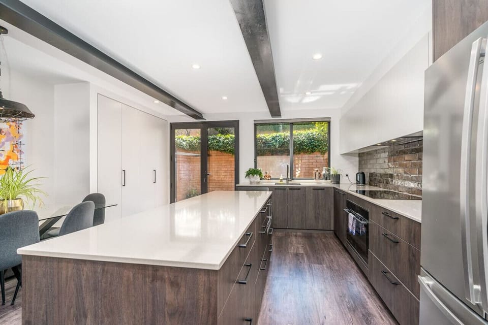 A spacious kitchen with rustic brick splashback and warm timber tones. Perfect for gathering and enjoying meals.