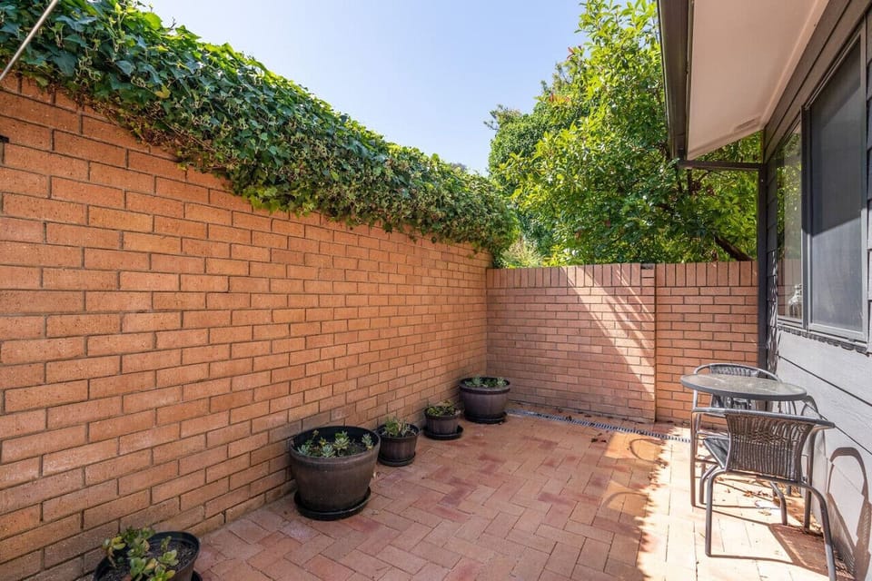 Private courtyard surrounded by lush greenery.