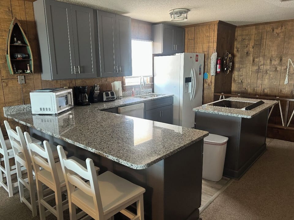 Full recently renovated kitchen, counter with four barstools