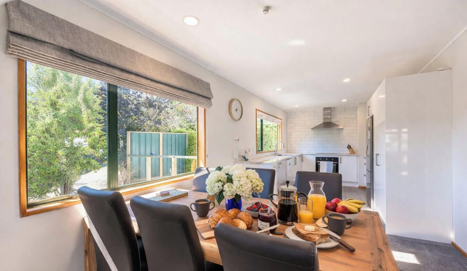 Open-plan dining area bathed in natural light, beautifully set for a relaxed meal with the group