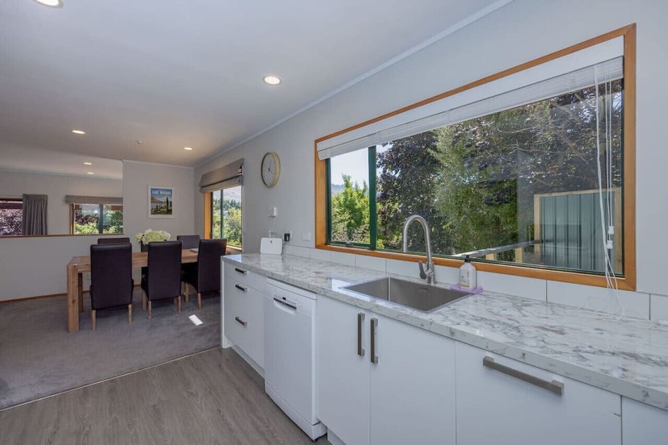 Modern kitchen with marble benchtops, large garden-view window, and everything you need