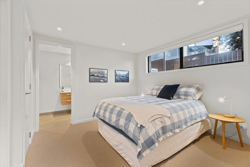 Spacious room with a queen bed, side tables, and lighting.