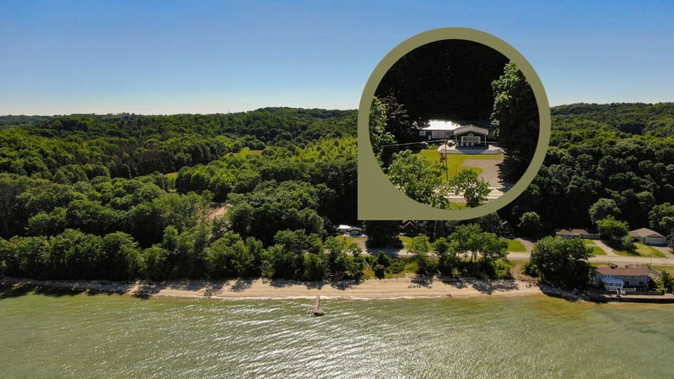 Elevated view of the home nestled among trees along the water.