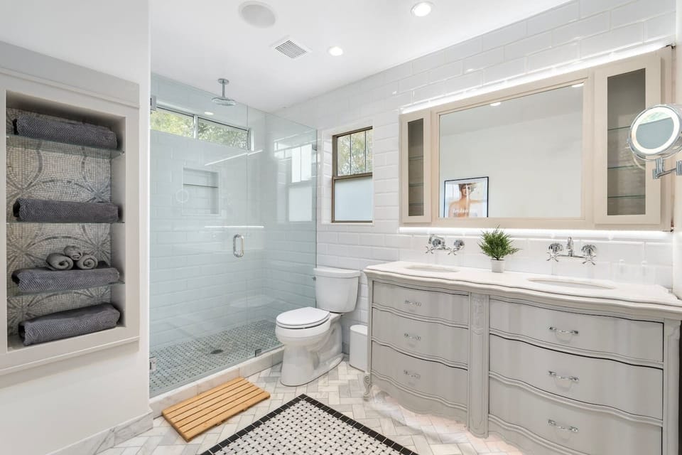 This master bathroom has a front facing and rain shower head, lighted make up mirror and surround sound!