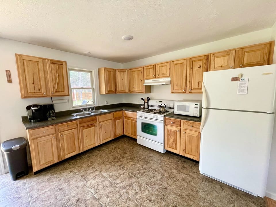 Full kitchen stocked with all the essentials including a Keurig and 12-cup coffee maker.