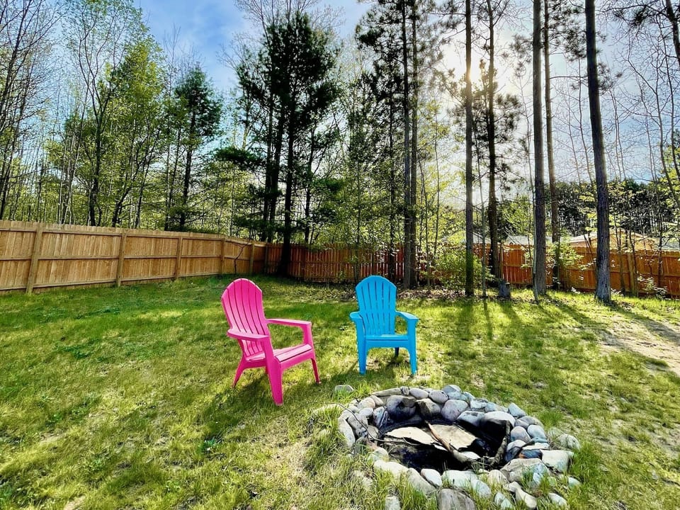 Fenced-in backyard includes fire pit.