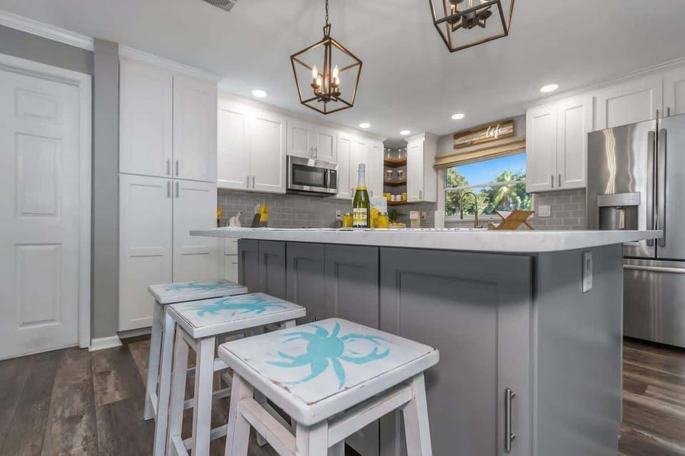 Large kitchen Island with beachy stools.