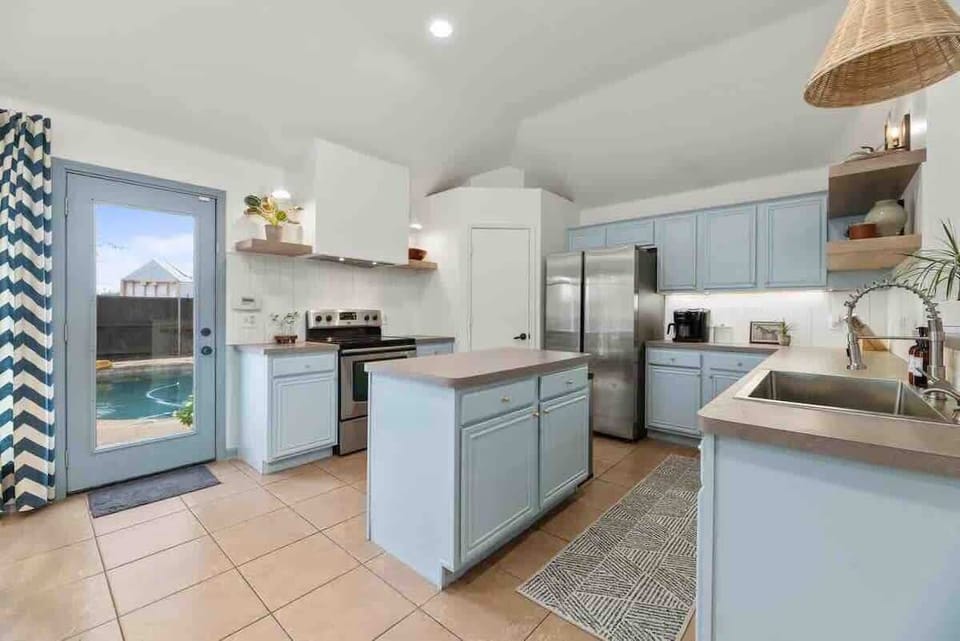 Experience the ultimate culinary haven in this expansive kitchen, complete with an impressive pantry and breathtaking views of the pool, perfect for inspiring creativity and warmth.