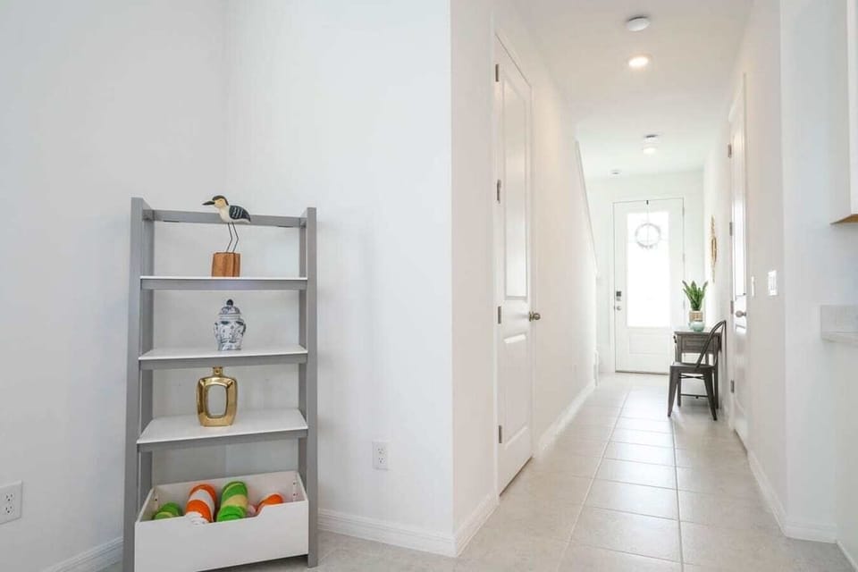 A clean and welcoming hallway leads you through the home. Thoughtful decor and bright lighting make every transition through the house feel warm and inviting.