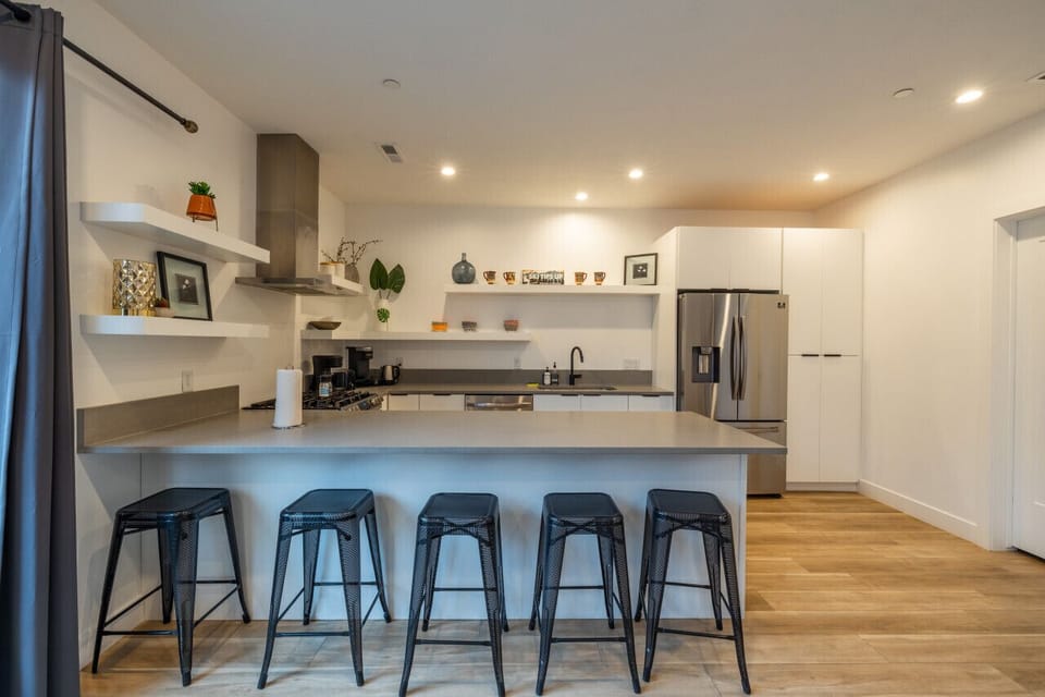Sleek, fully stocked kitchen with stainless-steel appliances, coffee station, and breakfast bar — perfect for cooking and connecting before hitting the canyons.
