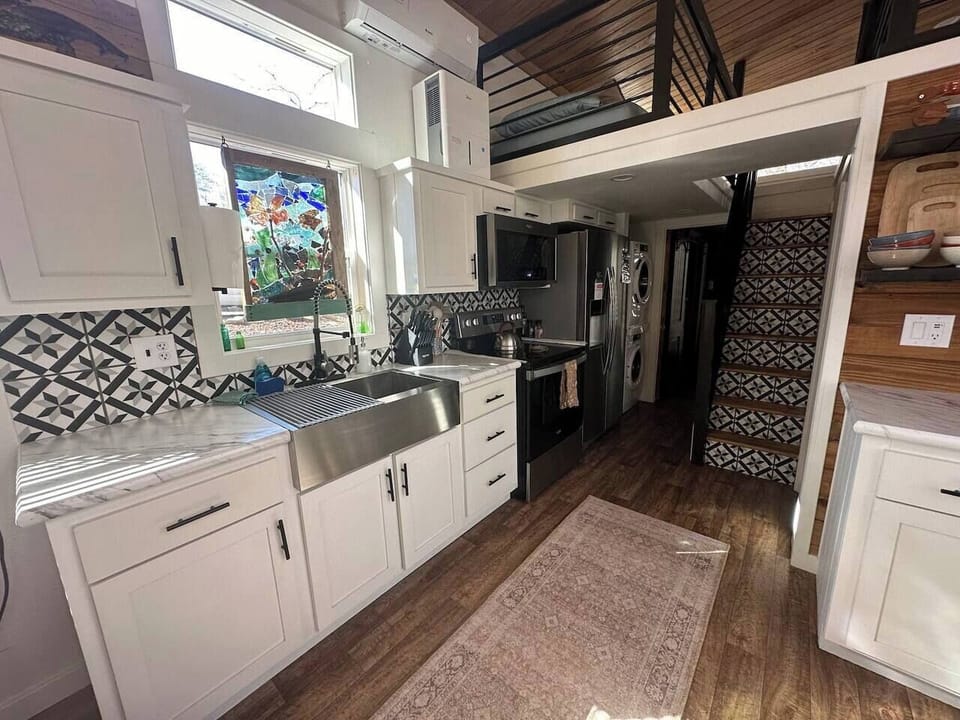 The kitchen is fully equipped with an electric stove, oven, microwave, Keurig and drip coffee makers, cookware, dinnerware, and pantry basics to make you feel right at home.