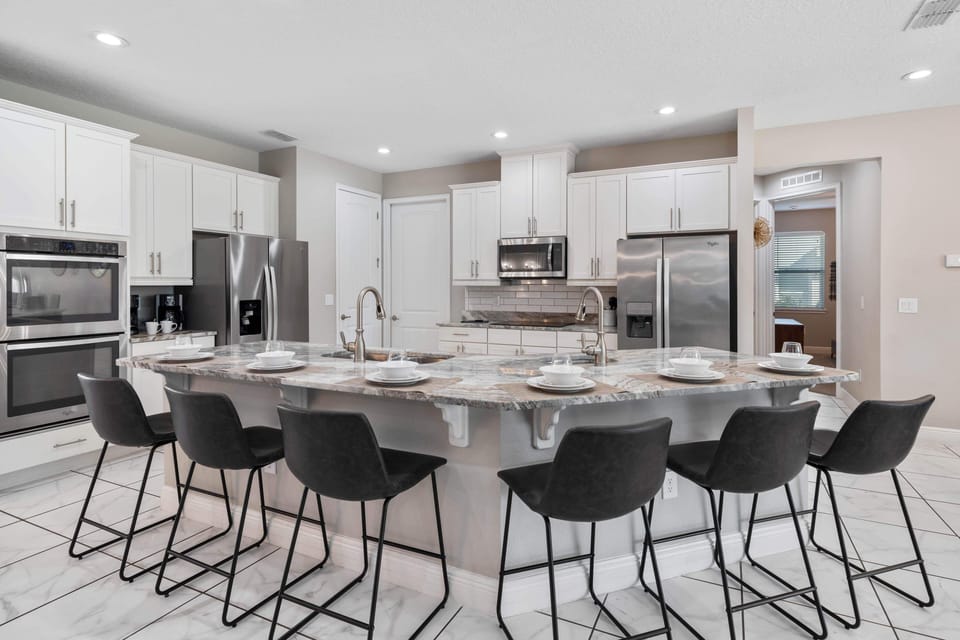 - Gourmet kitchen with stainless steel appliances and double oven  
- Large granite island with bar seating for casual dining  
- Fully equipped setup ideal for family meals and group cooking