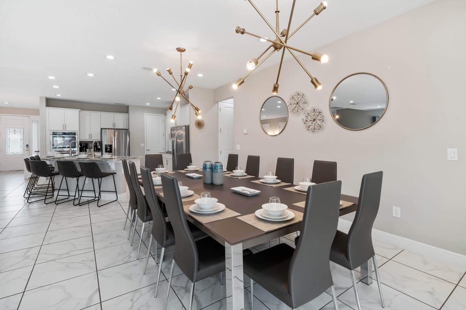 - Modern dining room with sleek table and stylish chairs  
- Unique lighting fixtures create warm inviting vibe  
- Perfect for family gatherings and group meals inside
