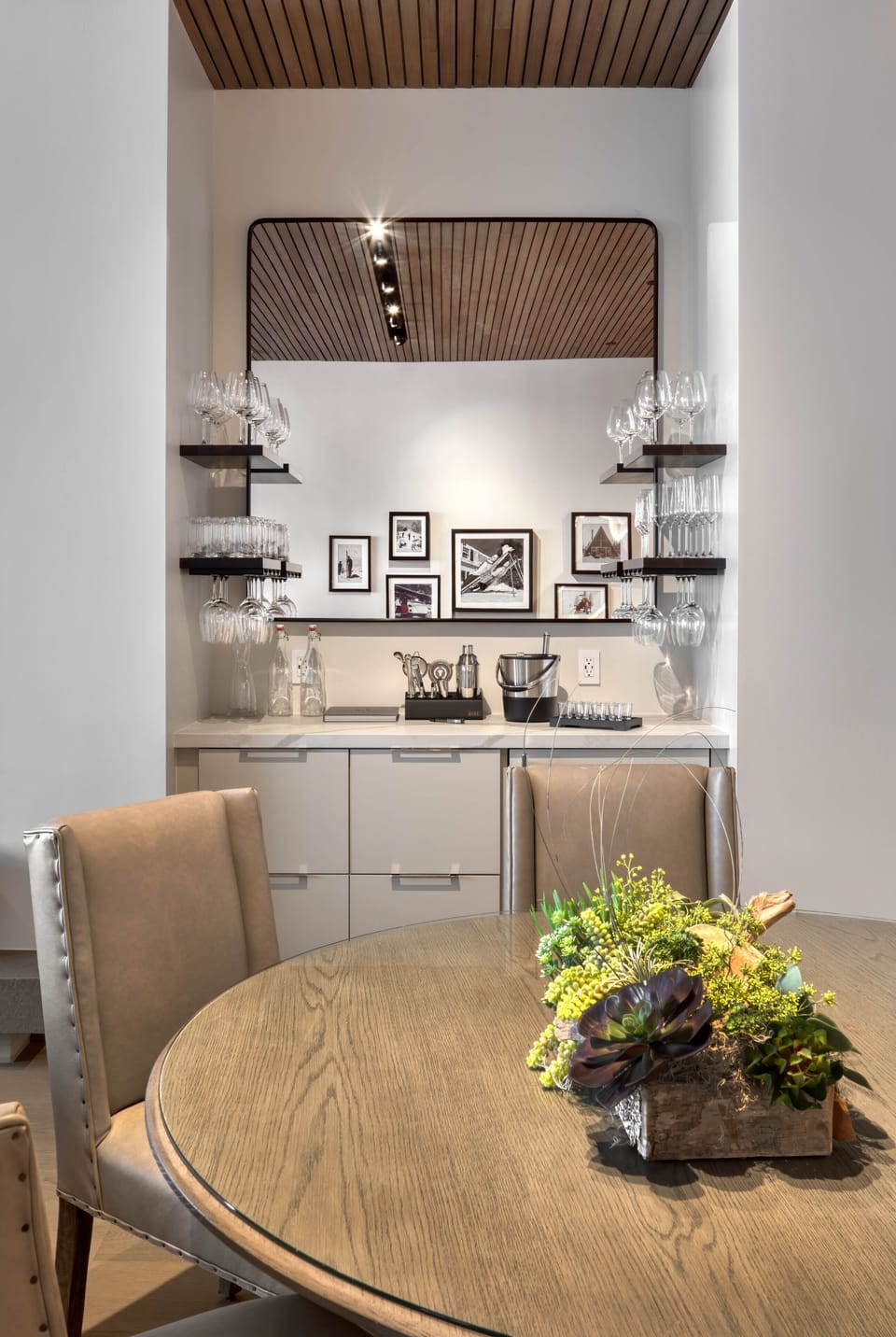 Bar area is stocked with wine and beer glasses, tumblers and wine refrigerator