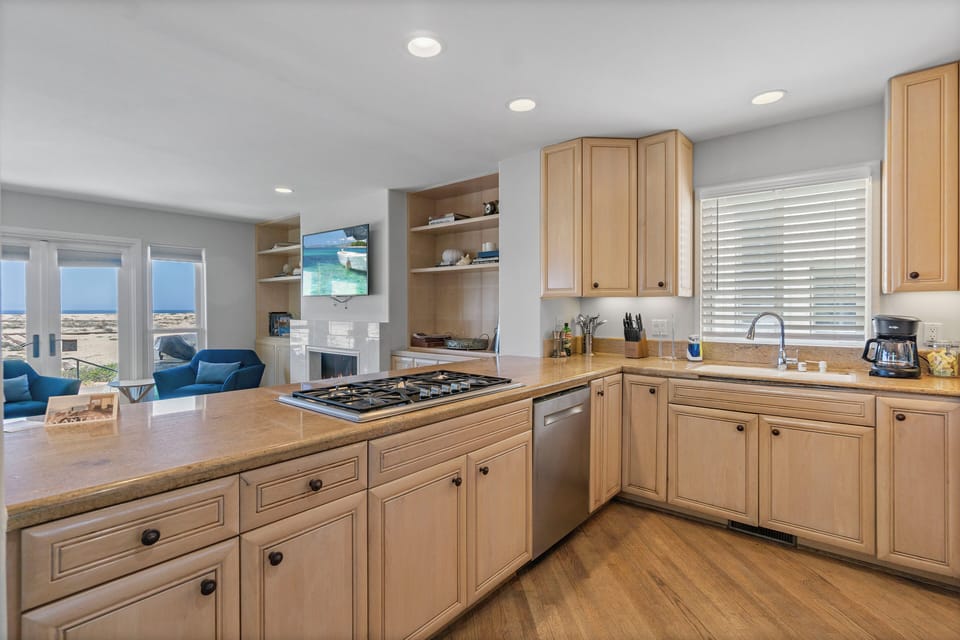 Fully equipped kitchen with barstool seating and a gas range.