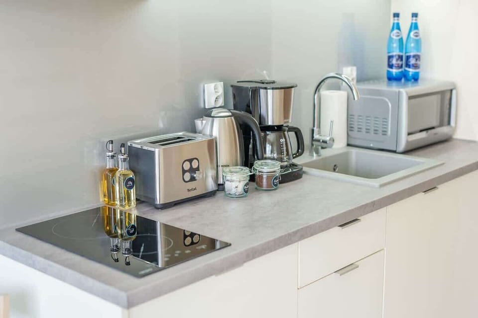 Kitchenette with kettle and refrigerator. 