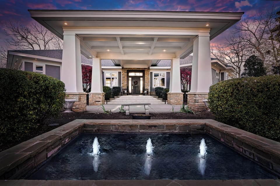 Welcome to this stunning vacation rental, featuring a beautifully lit exterior and picture perfect fountain