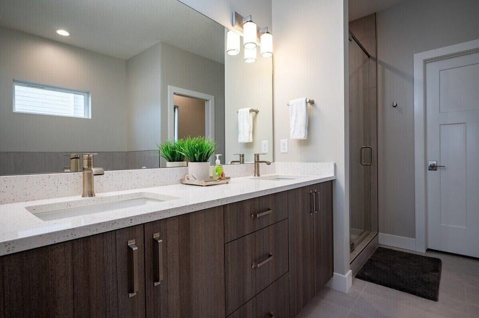 The bathroom features quartz countertops on the cabinets, ample storage, a hair dryer, and expansive mirror.
