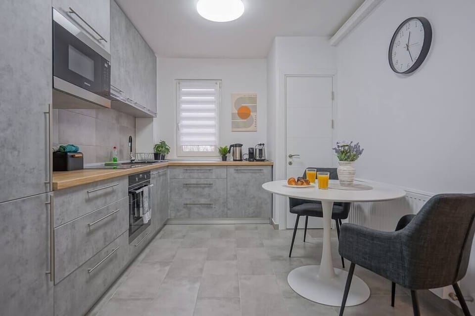 Fully equipped kitchen with fridge, freezer, oven, stove, coffee espresso machine, toaster, water kettle, microwave, cooking utensils, cooking basics and dining table.