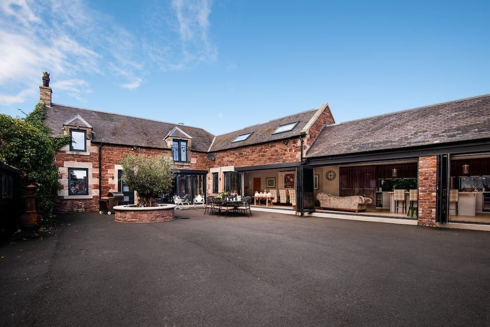 Coledale Stables - large courtyard area with outside furniture and bifold doors leading into the kitchen and dining area