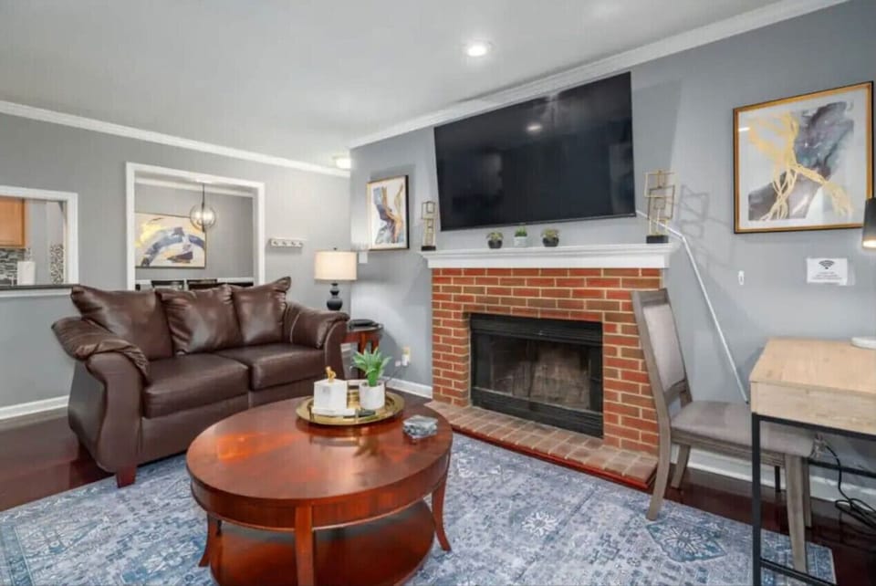 Inviting living room with two comfy 3‑seater couches, a queen sleeper sofa, a Smart flat‑screen TV, and patio access. Enjoy a cozy movie night, gather with friends, or get work done at the dedicated workspace overlooking the peaceful woodline.