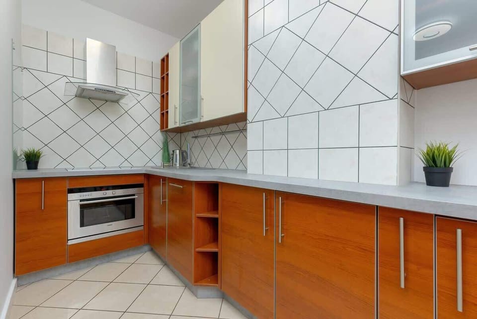 A fully equipped kitchen with wooden cabinets, a dining table, and modern appliances.